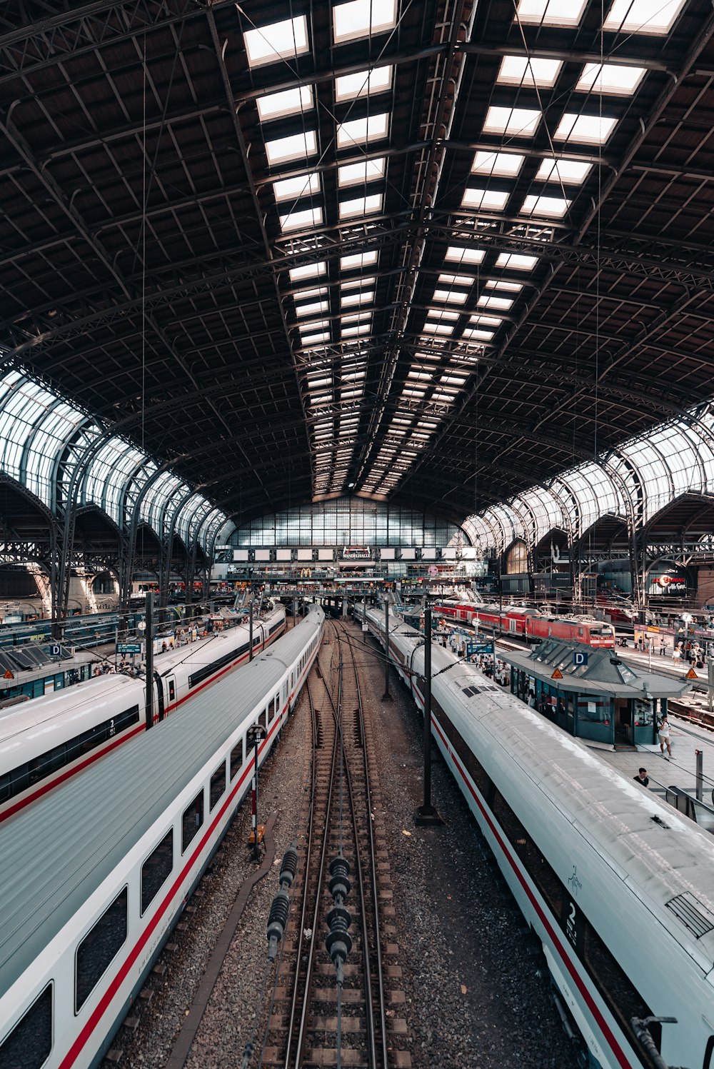 a train station with multiple trains parked inside of it