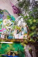 Close-up of a mural featuring natural elements and birds in a luxury garden setting.