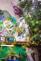 Modern mural with organic shapes blending into lush garden surroundings.