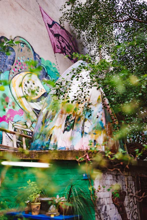 Modern mural with organic shapes blending into lush garden surroundings.