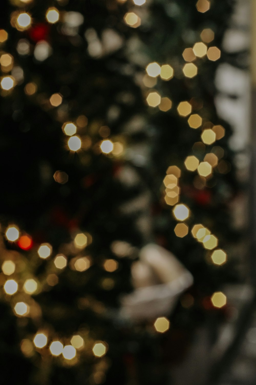 a close up of a cell phone near a christmas tree