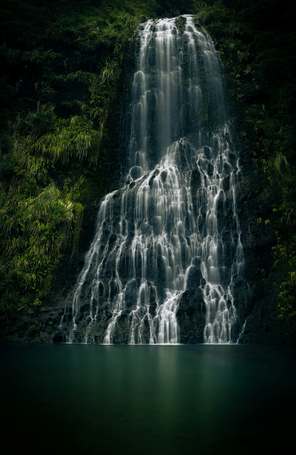 a large waterfall with a body of water below it