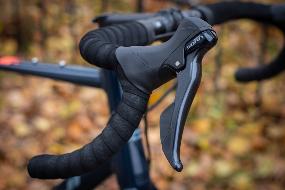 a close up of a bike's handlebars in the woods