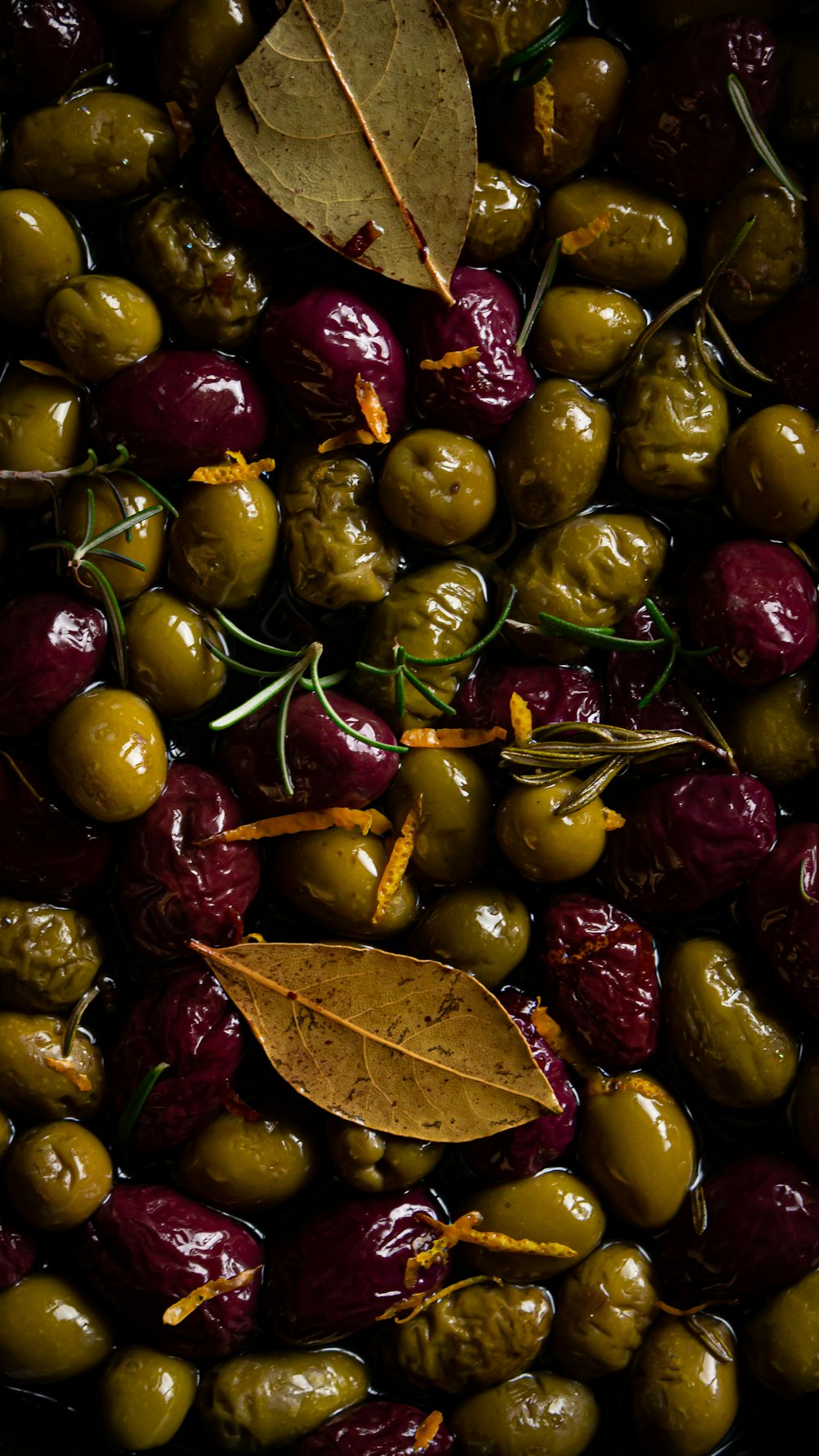 a bowl filled with green and red olives