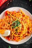 A plate of whole grain pasta topped with vegetables.