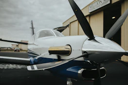 Vientoguard cover folded neatly beside a powered parachute ready for storage in a hangar.