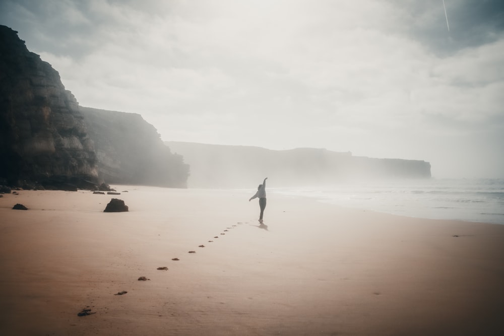 a person standing on a beach near the ocean