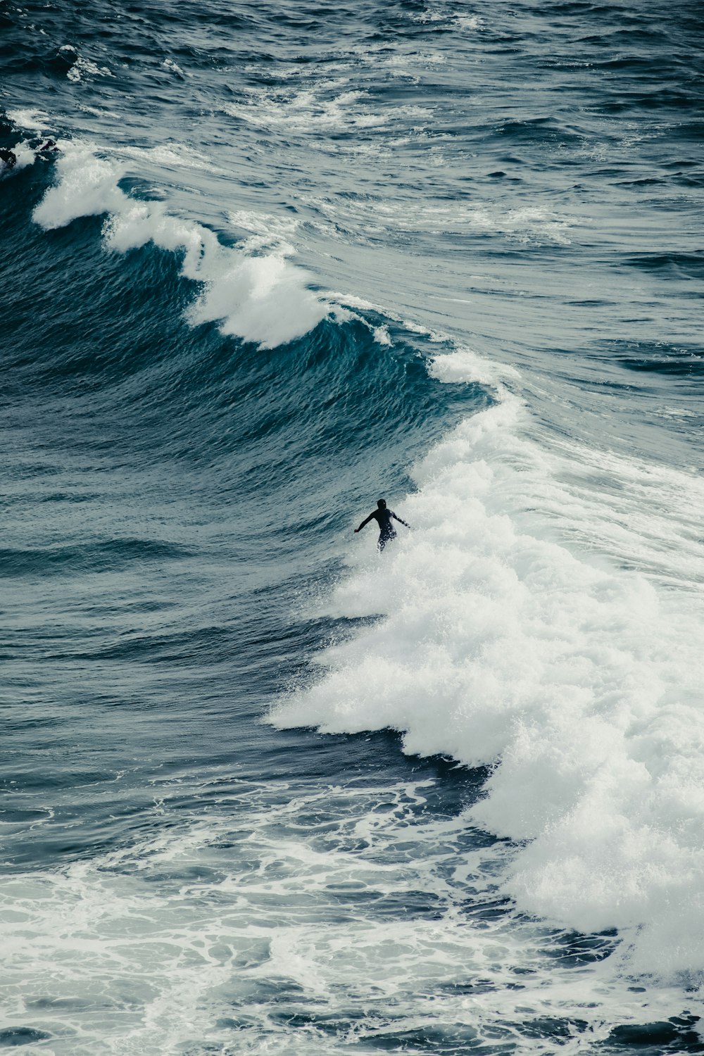 a man riding a wave on top of a surfboard