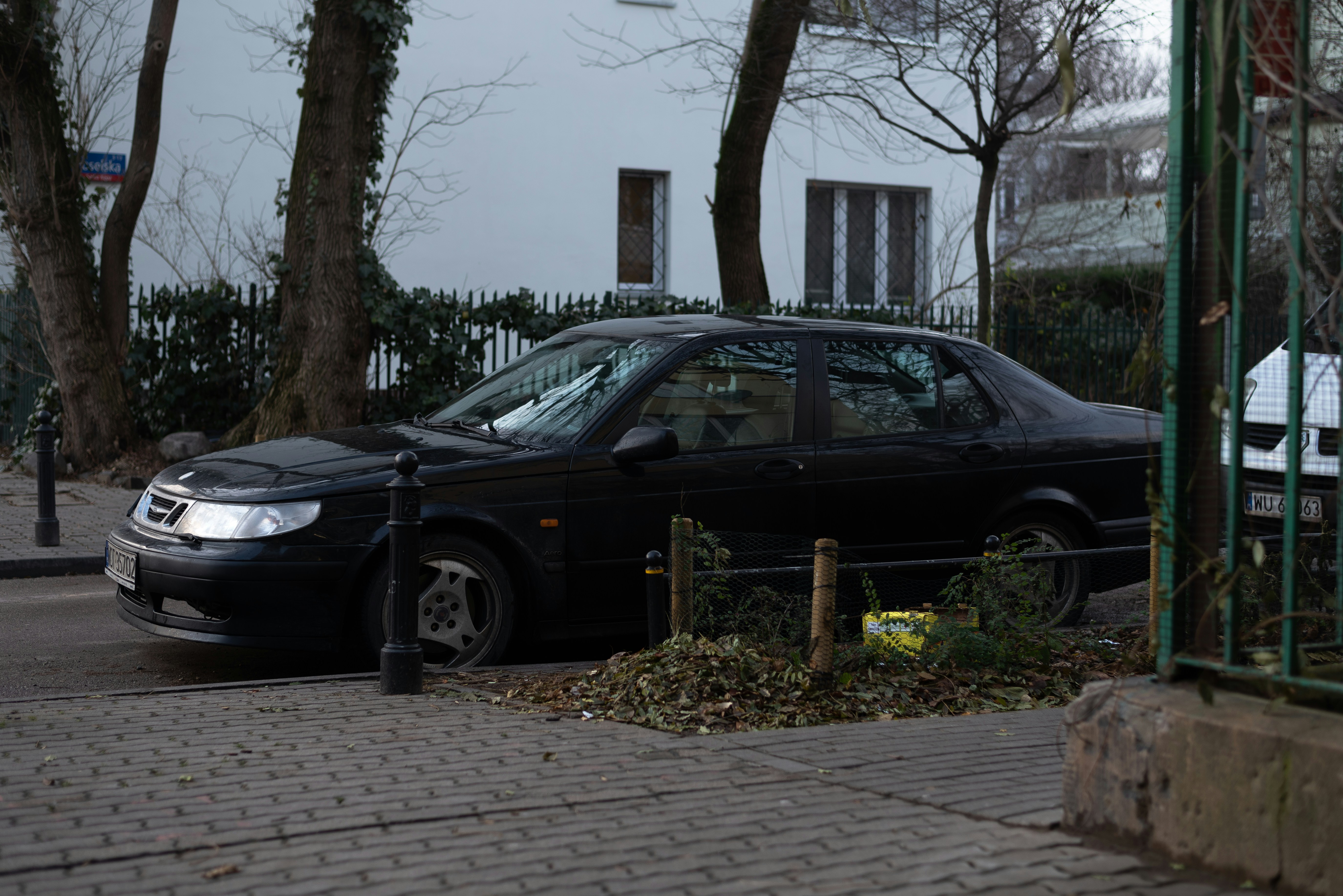 Sebuah mobil hitam diparkir di pinggir jalan