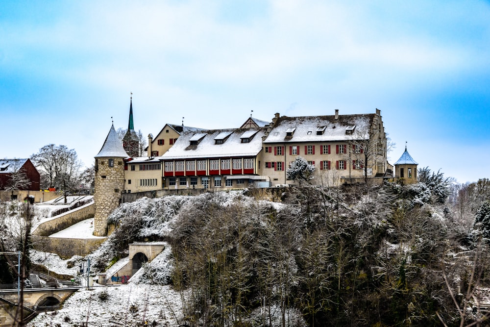 a castle with a bridge in front of it covered in snow