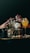 Several bottles and glasses of alcoholic beverages are arranged on a dimly lit table. Hands with painted nails are reaching for the bottles, and the drinks are garnished with fruits and leaves. The scene is set against a dark background, suggesting a bar or party atmosphere.