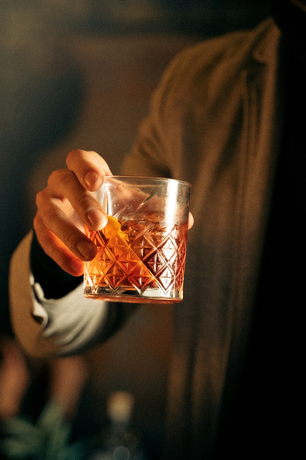 a person holding a glass with a drink in it