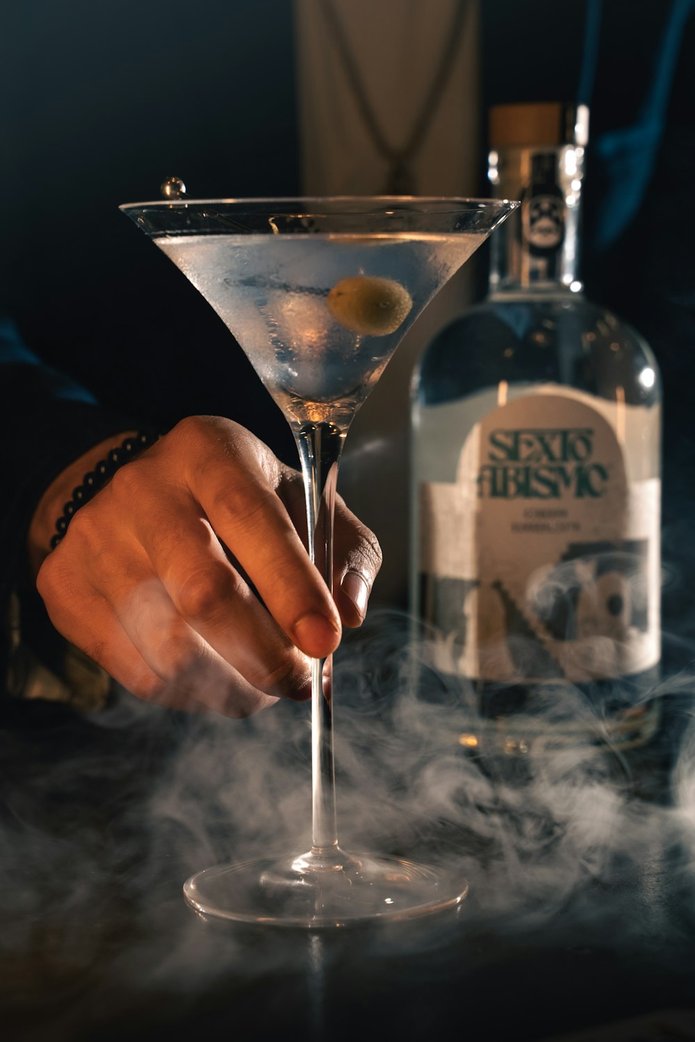 a person holding a martini glass with smoke coming out of it