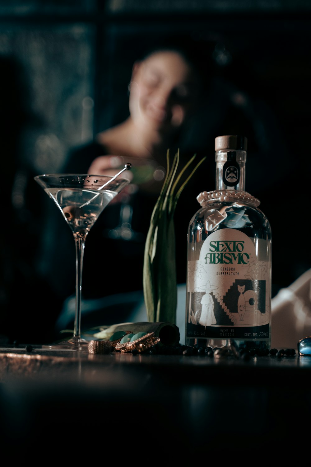 a man sitting at a table next to a bottle of alcohol