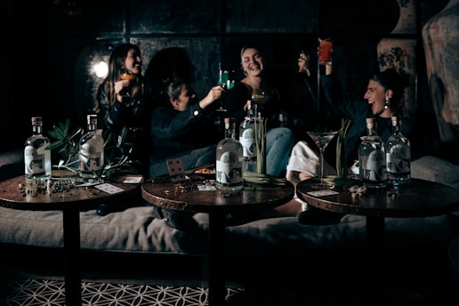 A lively group enjoying a guided rum tasting with glasses raised in a cozy setting