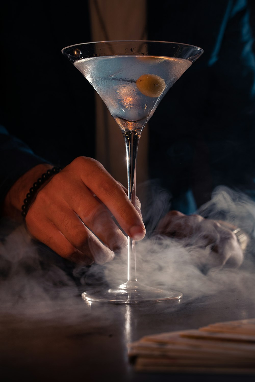 a person holding a glass filled with smoke
