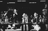 Guests laughing and participating in a Saturday trivia night, with wine glasses and score sheets on the tables.