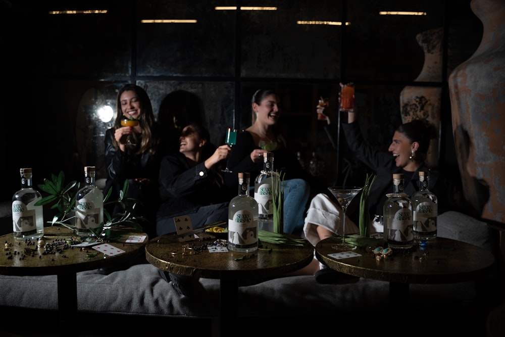 Un grupo de personas sentadas alrededor de una mesa con botellas