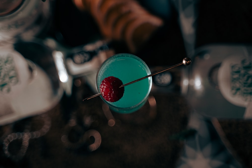 a blue cocktail with a strawberry on the top