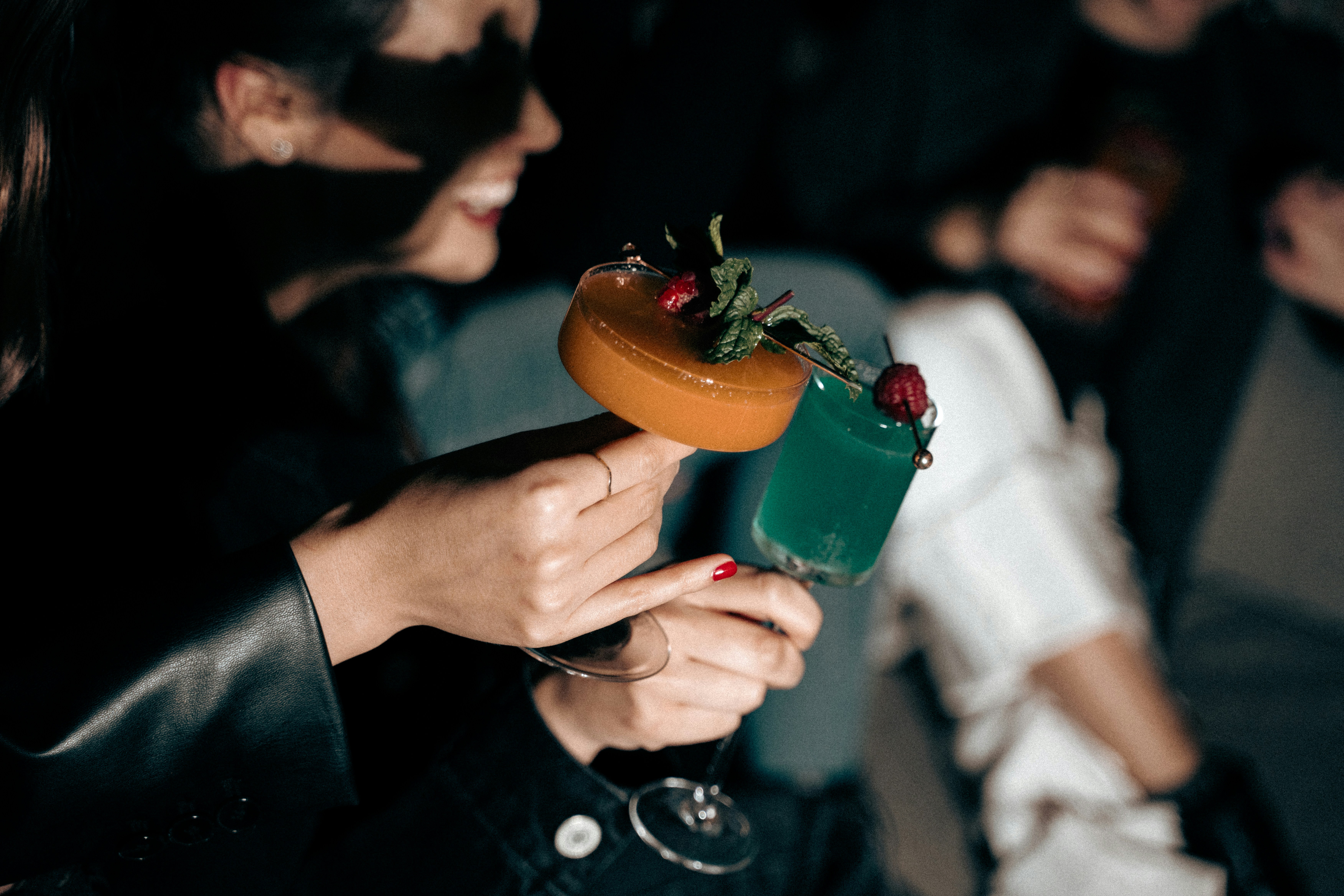 a woman holding a cocktail in her hand