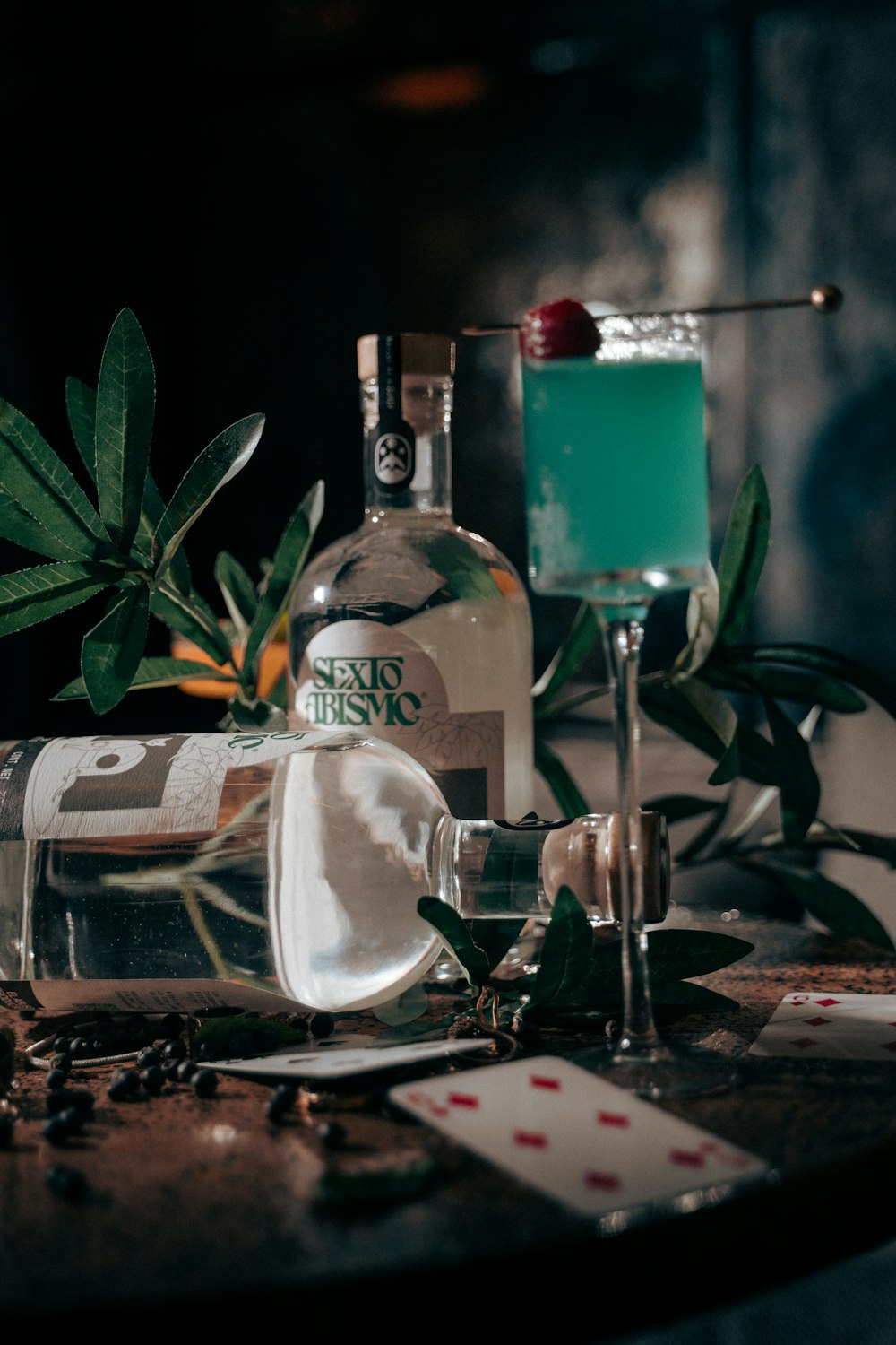 a table topped with a bottle of alcohol and a glass