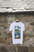 a white t - shirt hanging on a stone wall