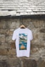 a white t - shirt hanging on a stone wall