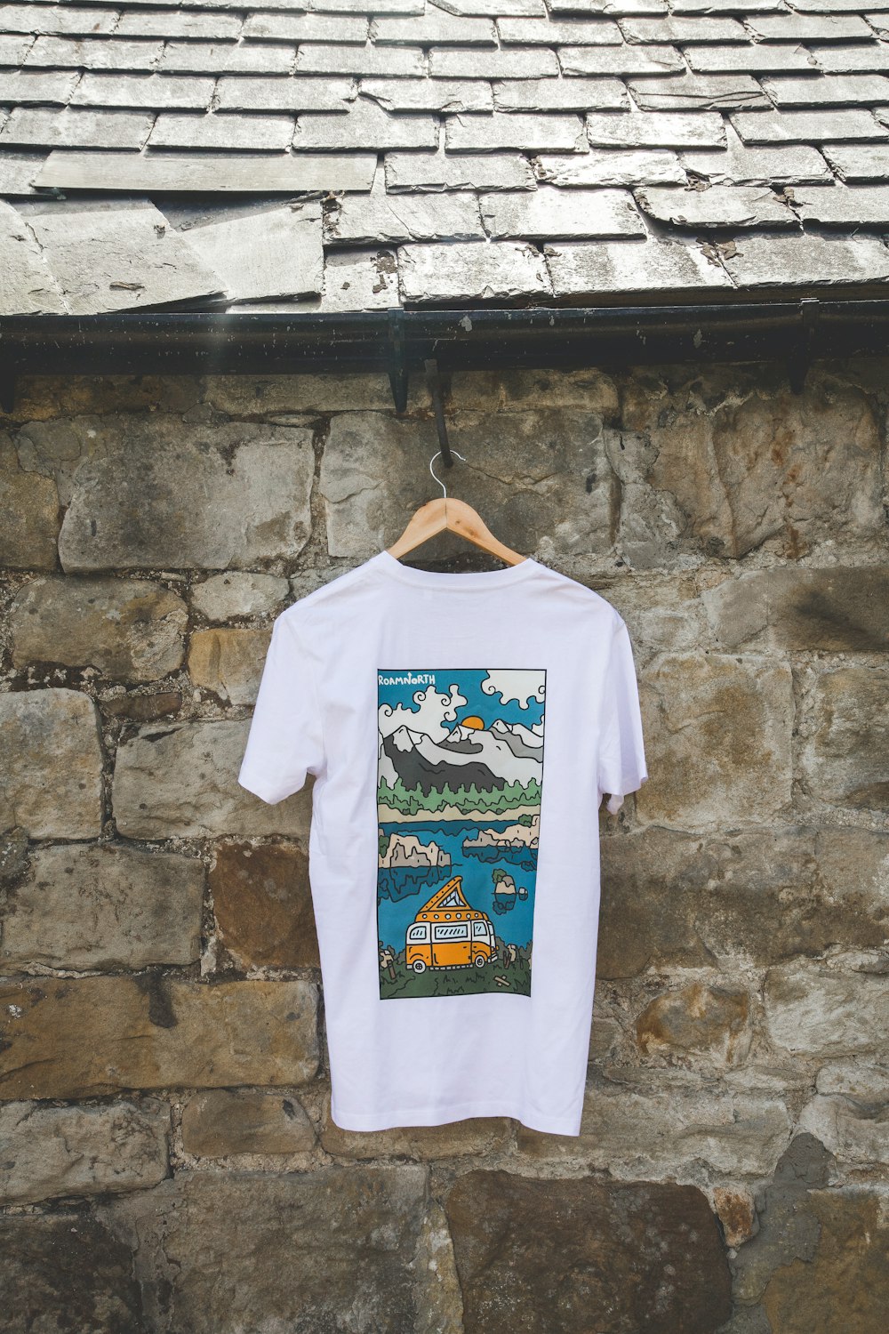 a white t - shirt hanging on a stone wall