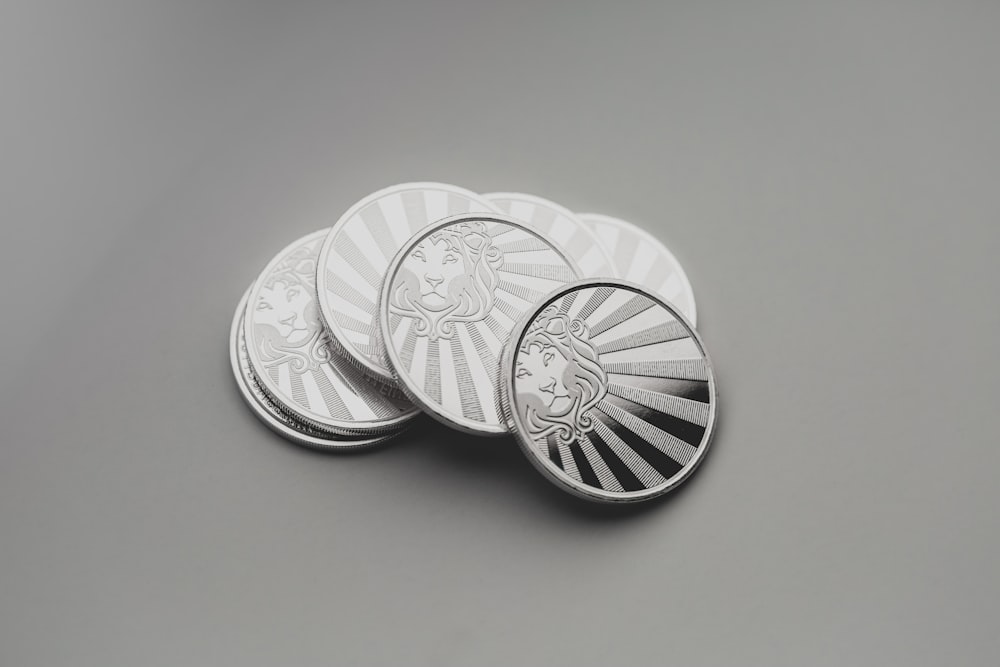 a set of four silver coins sitting on top of a table