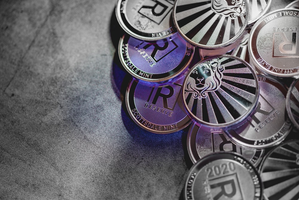 a pile of purple and silver coins sitting on top of a table