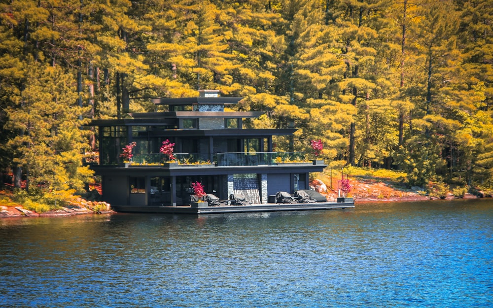 a house boat floating on top of a lake surrounded by trees