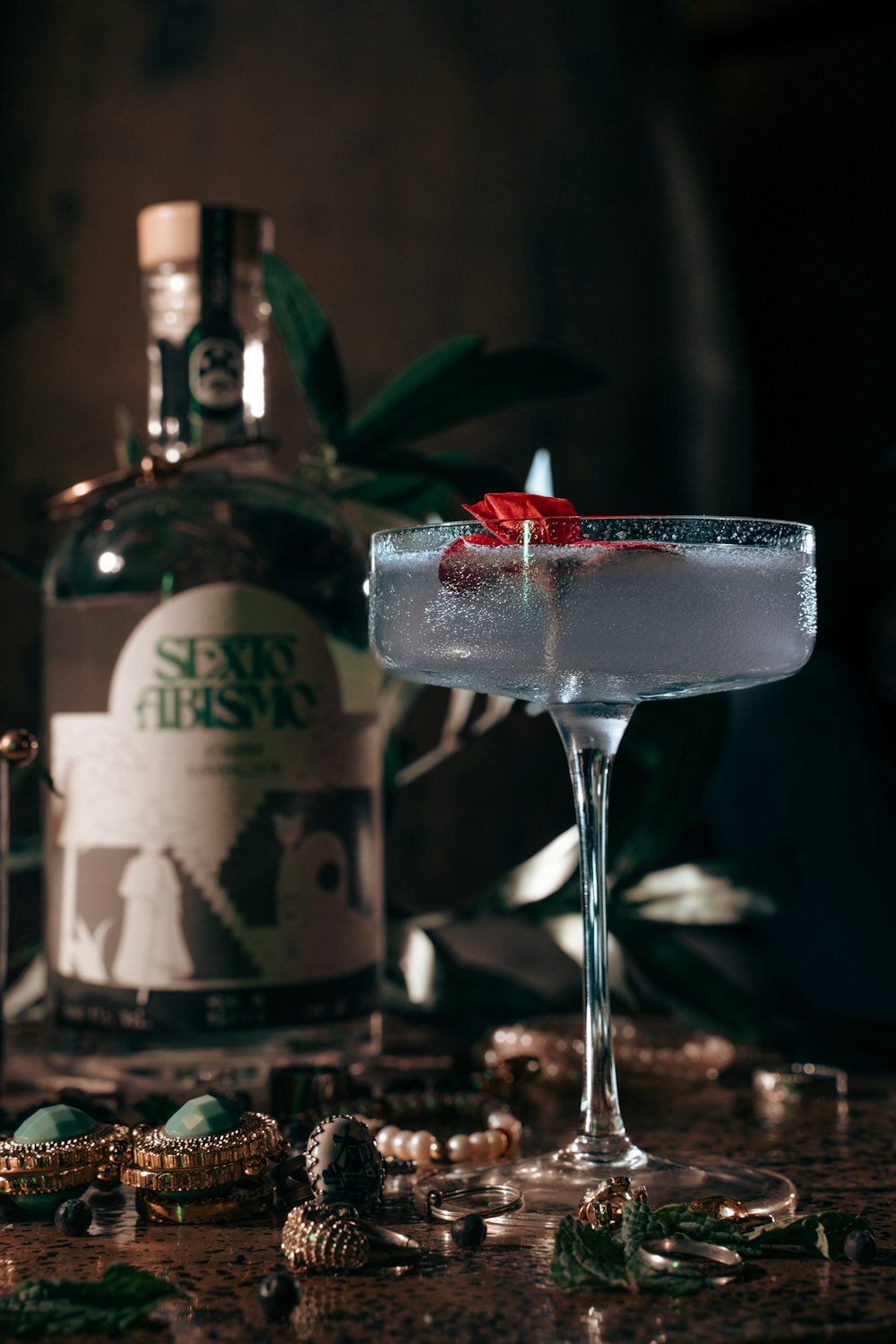 a close up of a drink in a glass near a bottle