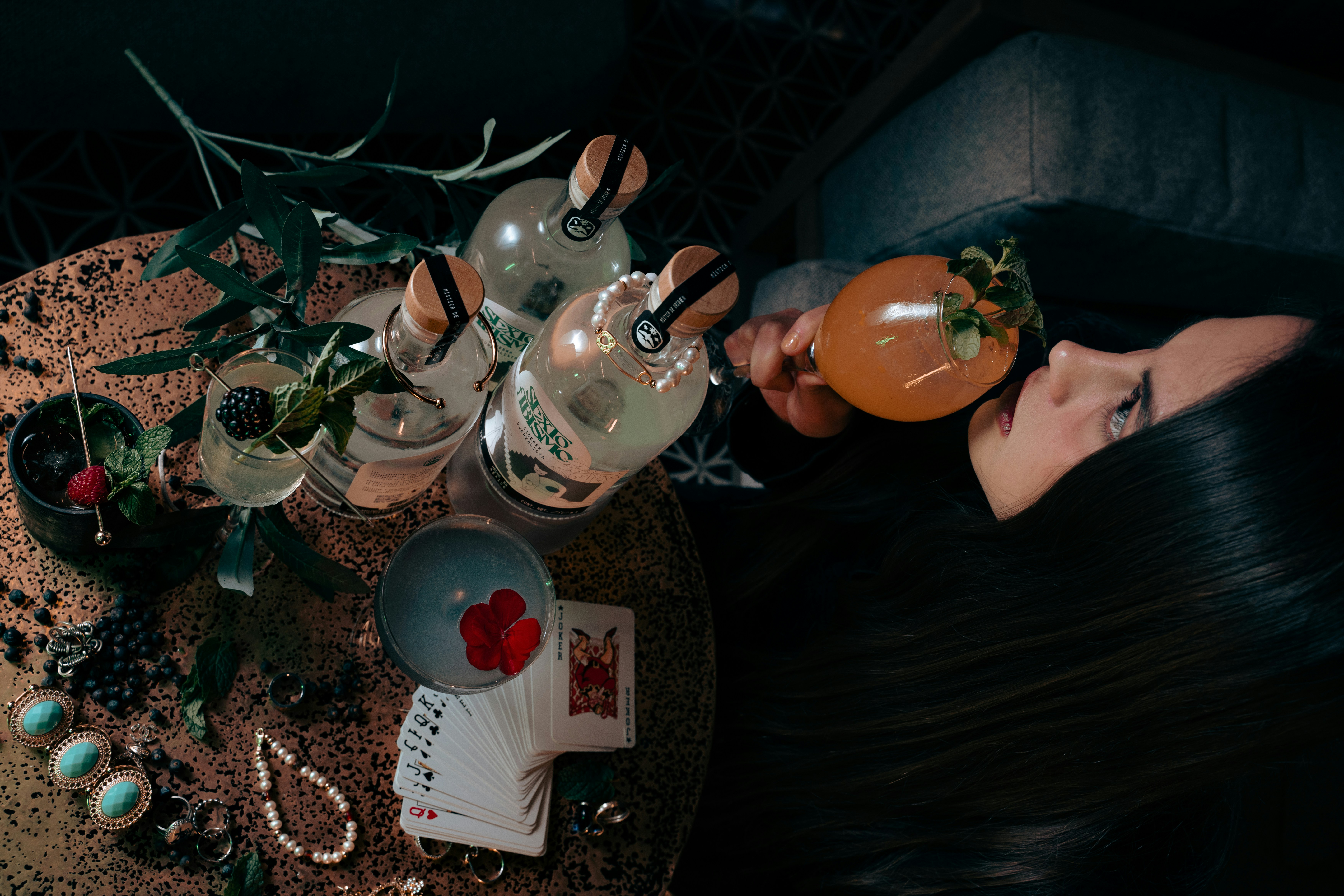 a woman laying on a table with a lot of tea and cards