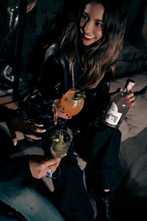 A close-up of a smiling woman enjoying a drink, radiating warmth and friendliness.