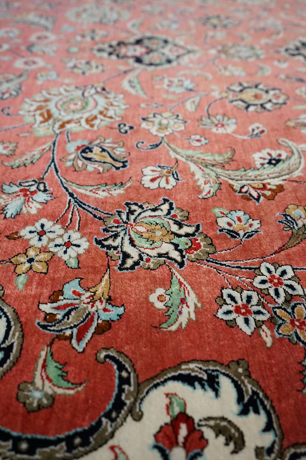 a close up of a red rug with a floral design