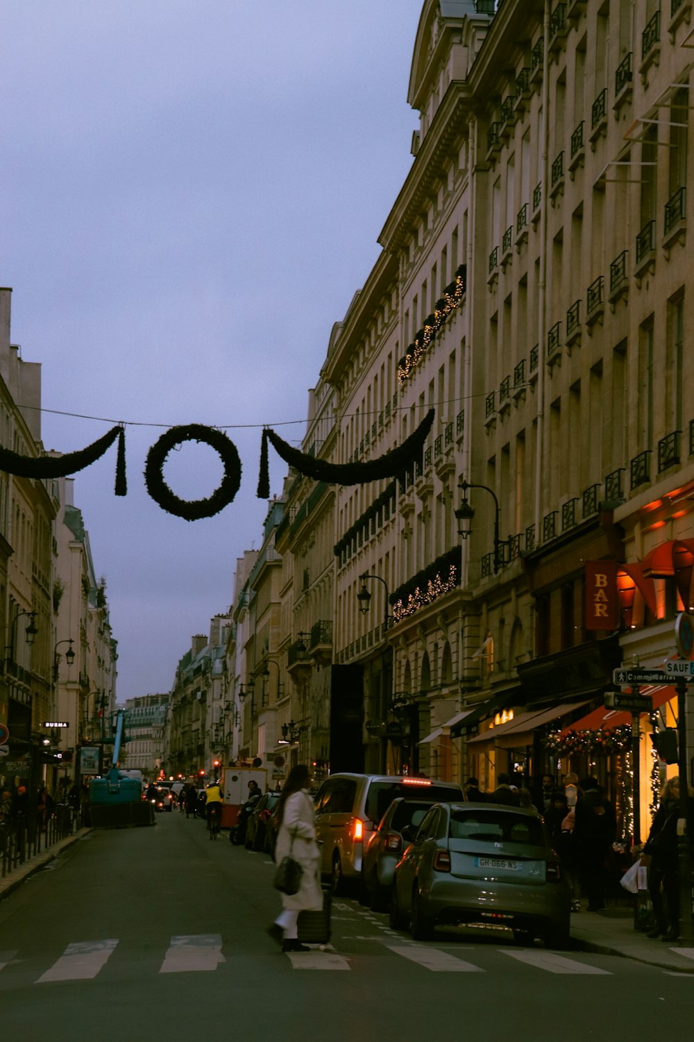 a city street with cars and people walking down it