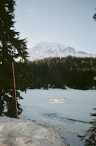 a snow covered lake with a mountain in the background