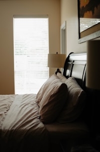 A cozy bedroom featuring custom window treatments with layered curtains and blinds.