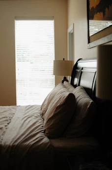 A cozy bedroom with blackout roller blinds closed, creating a dark restful space.