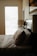 Cozy bedroom with neatly arranged bed linens and soft natural lighting.