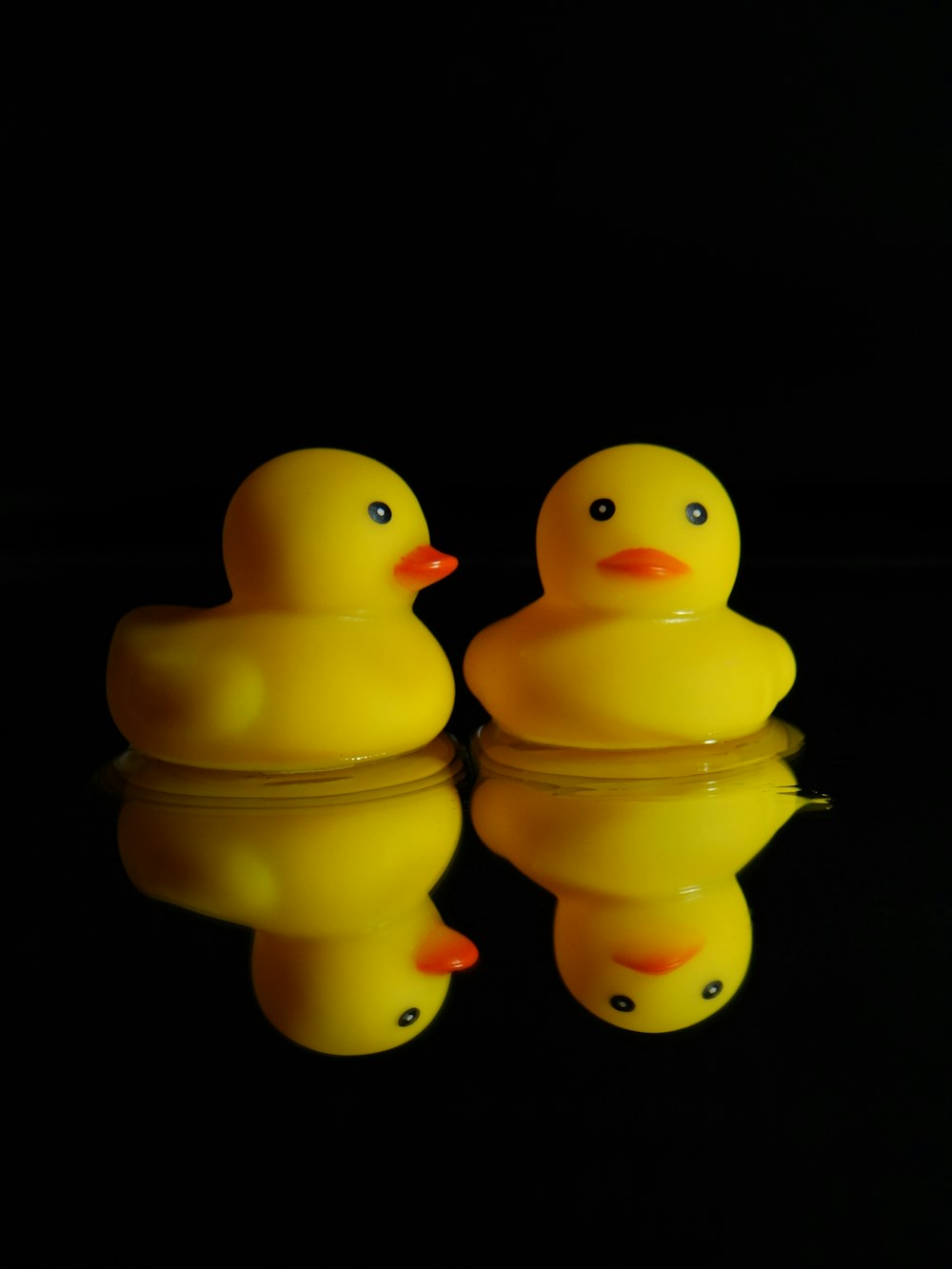 a couple of yellow rubber ducks sitting on top of a table