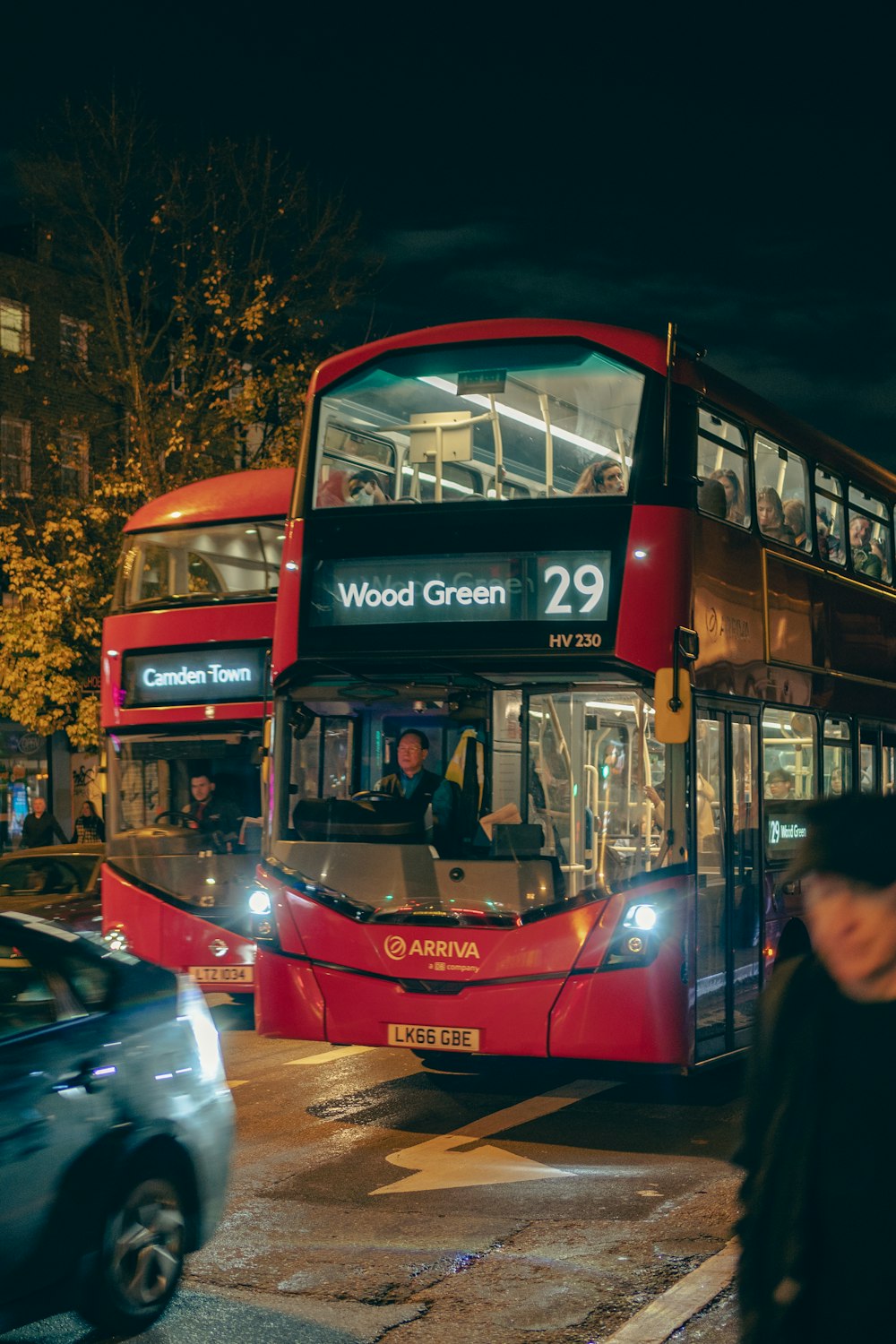 a red double decker bus driving down a street