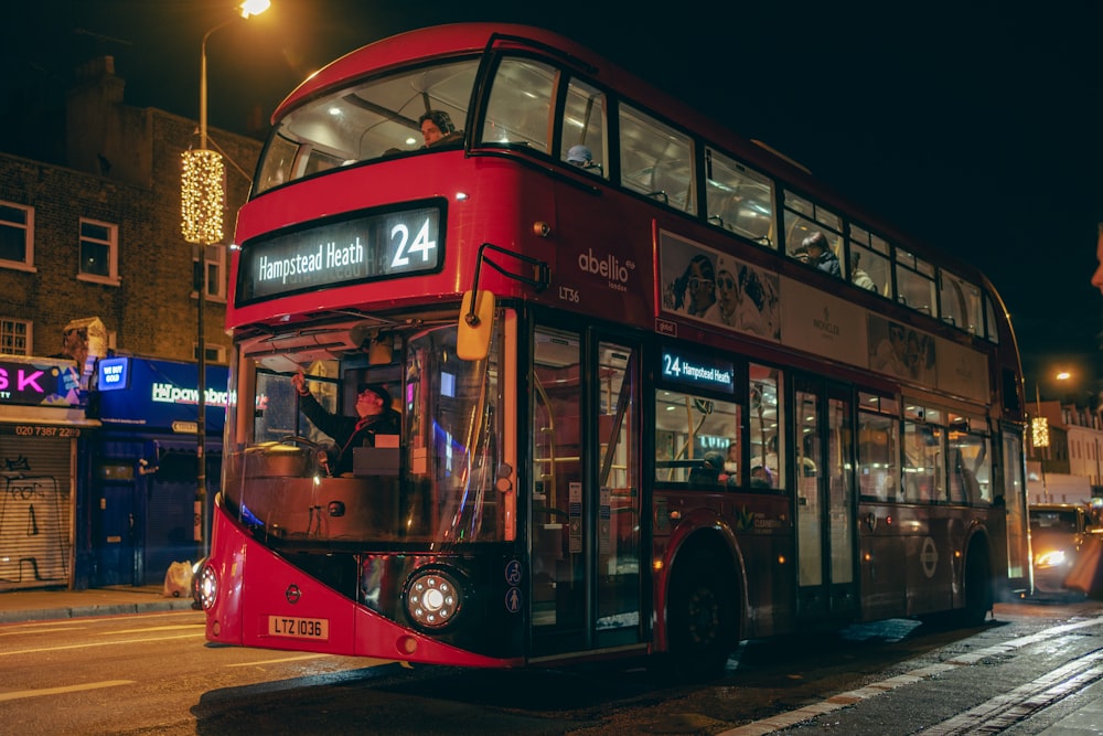 a red double decker bus driving down a street