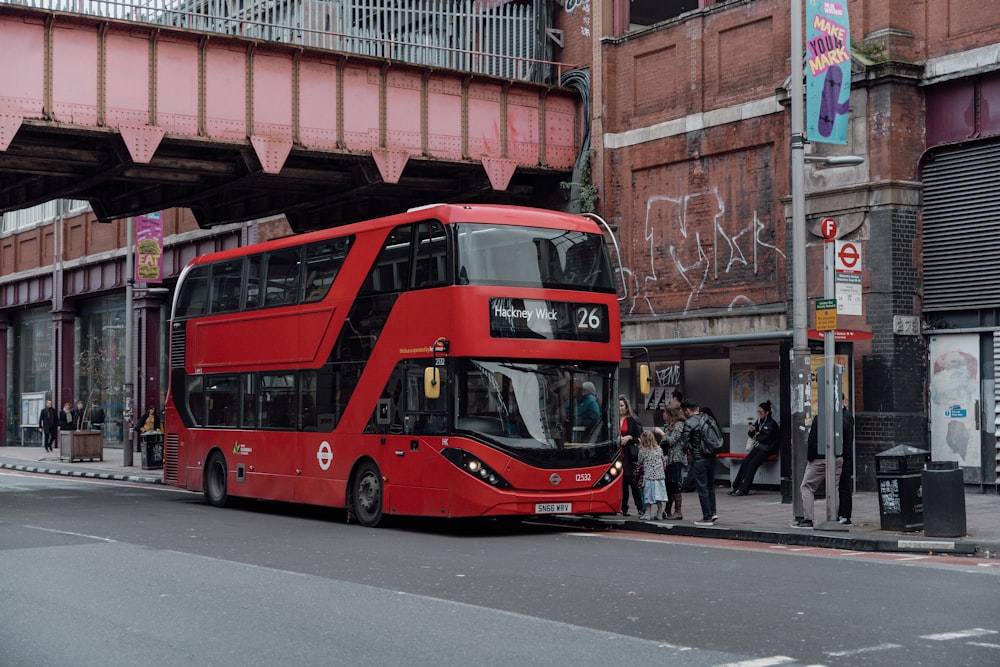 a red double decker bus parked in front of a building