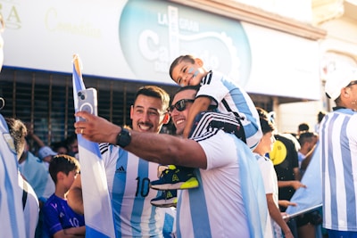 A group of international fans sharing smiles and high-fives before kickoff.