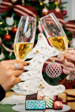 Close-up of hands holding drinks with festive decorations in the background