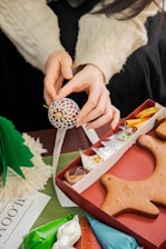 Artisan carefully crafting a fruit-inspired ornament in a cozy workshop.