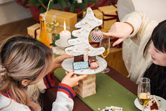 two women sitting at a table with a plate of food