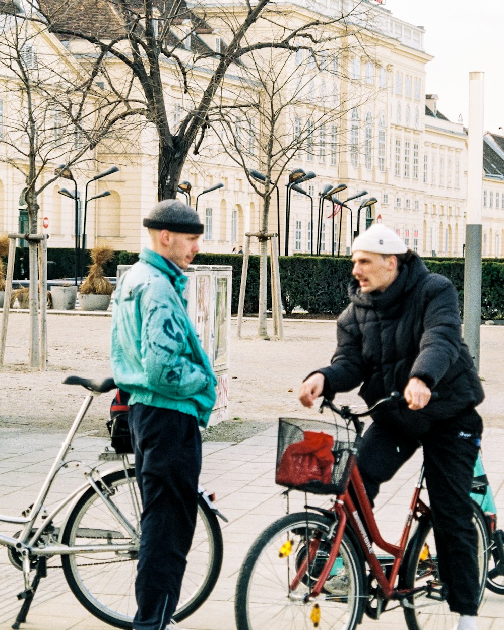 a man riding a bike next to another man on a sidewalk