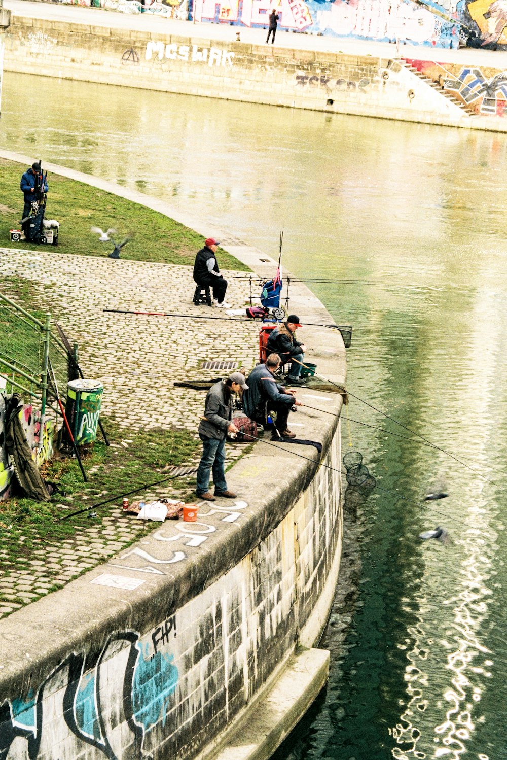 a group of people sitting on the side of a river
